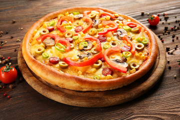 Delicious pizza with pepper on wooden table
