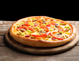 Delicious pizza with vegetables on black background