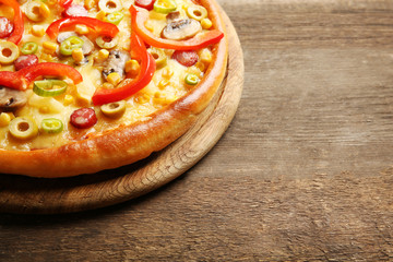 Delicious pizza on wooden background