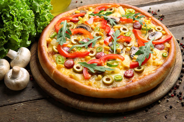 Delicious pizza with salad and Champignon on wooden background