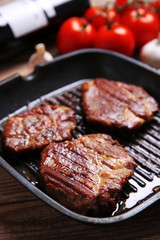 Roasted beef fillet on pan, on wooden background
