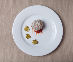 Cutlet with rice, slices of pickle and ketchup on white plate on