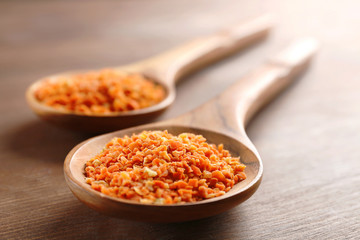Two wooden spoons with spice on the table, close-up