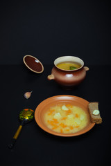 Rice soup in a clay pot on a black table or background. Toned