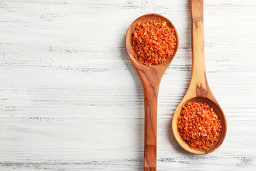 Two wooden spoons with spice on the table, close-up