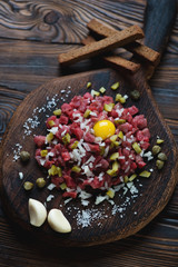 Wooden rustic cutting board with beef tartar, high angle view