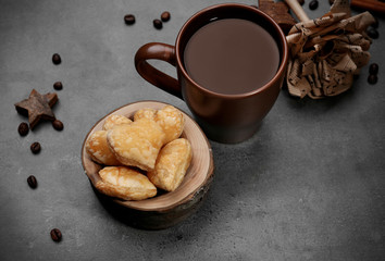 Heart shaped biscuits in bowl with dried spices on dark grey background