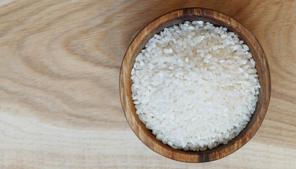 Fototapeta na wymiar Rice in a wooden plate, horizontal view from above, rustic