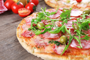 Delicious tasty pizzas with ingredients on table, closeup