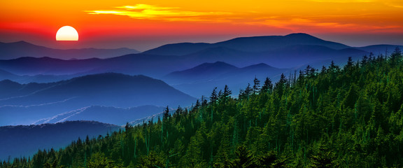 Obrazy na Szkle  Zadymiony zachód słońca w górach