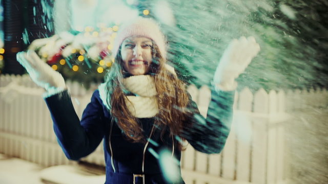 Winter Christmas Girl. Beautiful Woman Blowing Snow