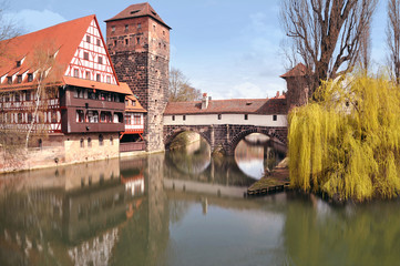 Old buildings, arch bridge and tree reflection in water. Nuremberg, Bayern, Germany