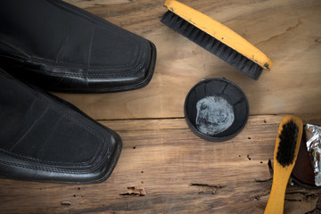 old shoes with shoe polish and shoe brush on wood