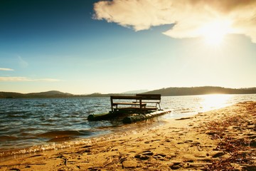 Abandoned old rusty paddle boat stuck on sand of beach. Wavy level, islad on horizon. Autumn weather