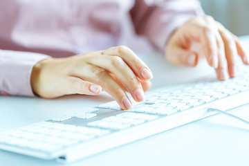 Woman office worker typing on the keyboard