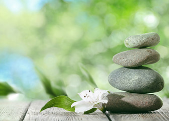 Spa stones on table,  on green nature background