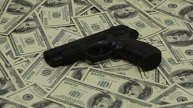 The gun with a silencer and dollars
