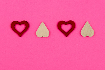 Four red heart shape symbols isolated over pink background, love concept