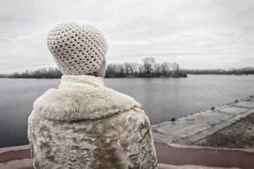 Woman Looking at the River during a Sad Winter Day