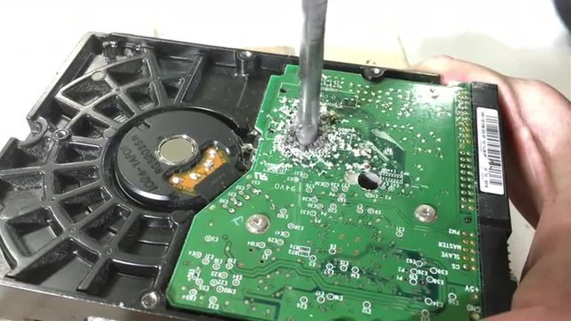 Drill bit going through hard disk drive of computer to ruin the data.