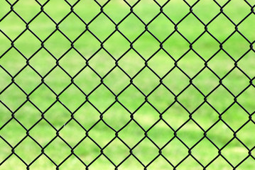 Fototapeta premium iron net fence against green meadow