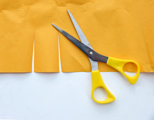 scissors cutting yellow paper