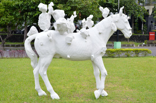 white horse statue on green grass