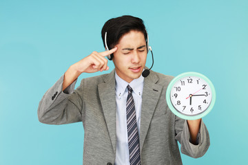 時計を持つ疲れた表情のオペレーター
