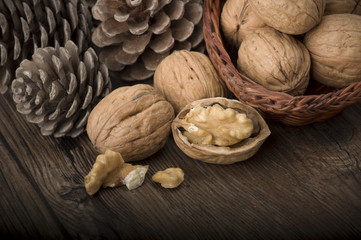 Walnut kernels and whole walnuts on rustic old wooden table
