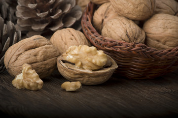 Walnut kernels and whole walnuts on rustic old wooden table