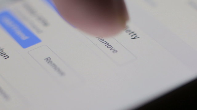 A young male uses a tablet with his finger, swiping and pinching. Close-up