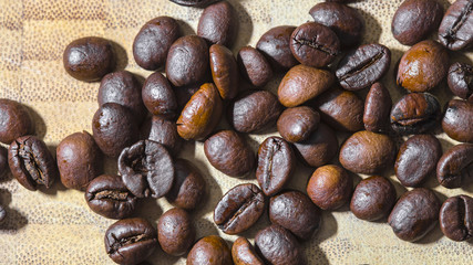 Brown raw coffee beans on a wooden background