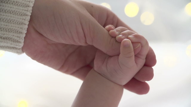 Mother and newborn daughter. Hand in hand.Slow motion.