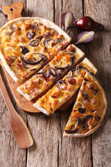 Delicious sliced pie flammkuchen close-up on the table. Vertical
