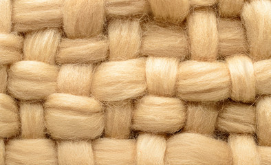 Interweaving beige wool closeup. Background made of wool for felting