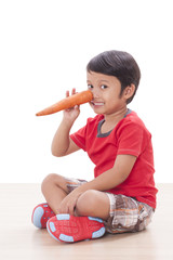Happy boy with a carrot. Healthy food concept. 