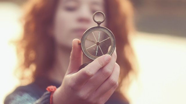 Teenager girl  holding an old compass in hand
