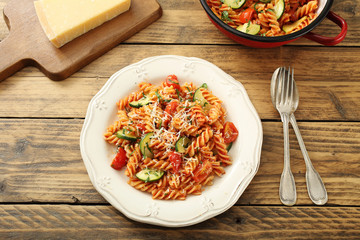 vista dall'alto Pasta italiana con zucchini e pomodoro su sfondo legno rustico