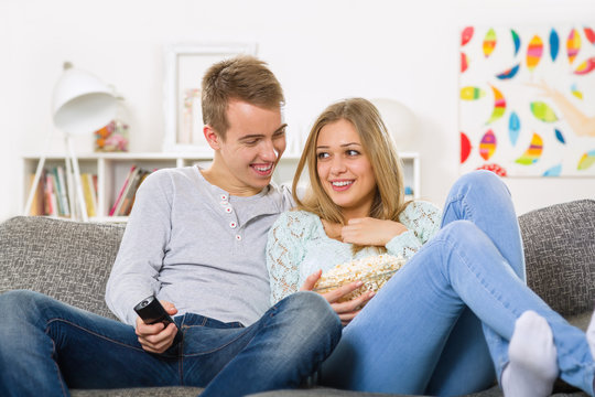 young couple watching tv and relaxing on sofa