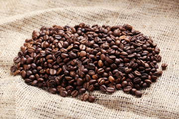 Fototapeta premium Roasted coffee beans on a sack, close up