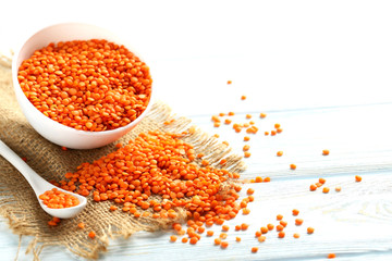 Red lentils in bowl on a blue wooden table