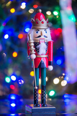 Soldier nutcracker statue standing in front of decorated Christm