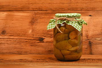 One jar of pear compote at brown vintage wood surface