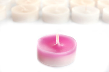 Fototapeta na wymiar Pink and white small candles, isolated on white