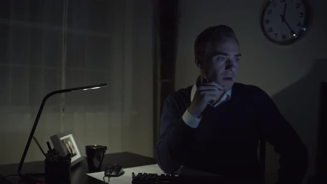 A man works at a clean desk with a computer He is guilty or suicidal