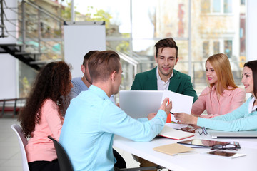 Fototapeta premium Young business people discussing a new project at the meeting in a conference room