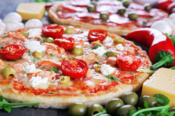 Delicious tasty pizza with ingredients on table, closeup