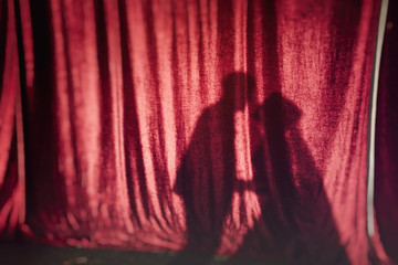 shadows from the kissing couple on red fabric
