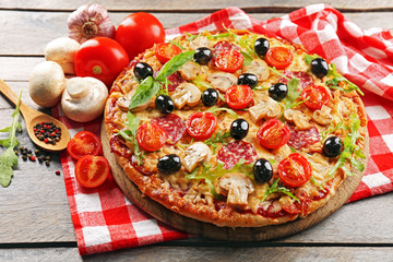 Delicious tasty pizza with ingredients on wooden table