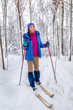 smiling young woman skier in winter forest